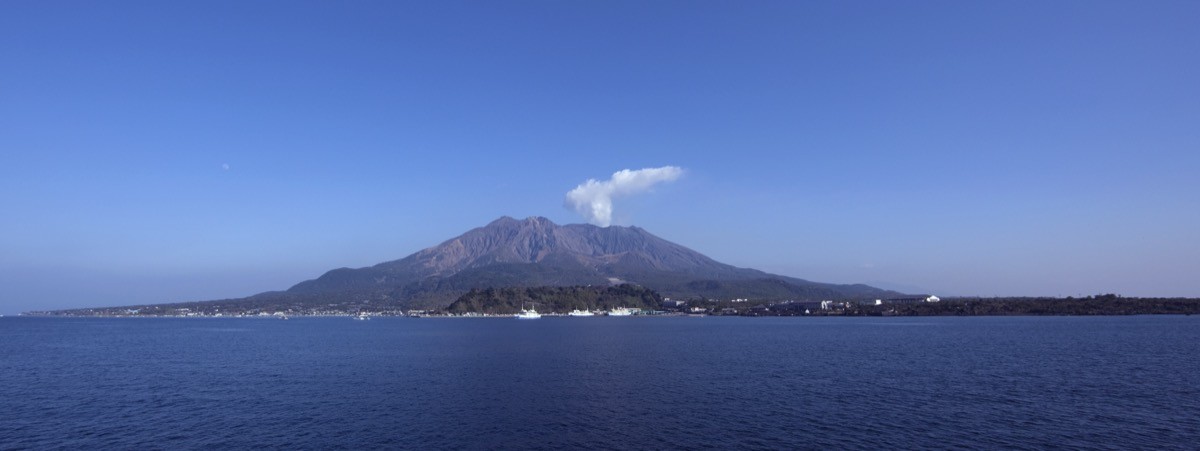 The active volcano Sakurajima with a smoke plume, seen across Kinko Bay